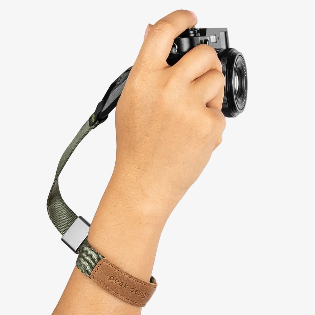 hand holding camera with sage peak design cuff strap